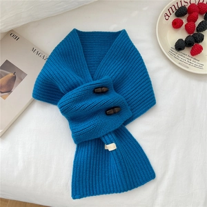 Détail d'une écharpe en maille bleu marine avec boutons en corne sur lin blanc pur