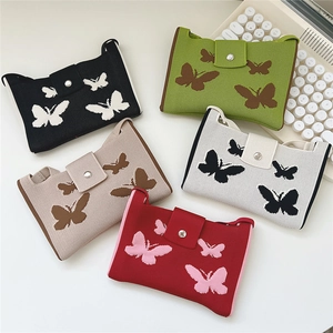 Flat lay of five colorful knitted butterfly bags with magnetic buckles and strap