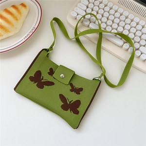 Detailed knit texture of green crossbody bag with brown butterfly pattern and magnetic buckle