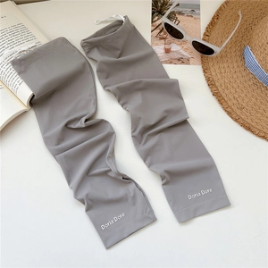 Grey cooling sun protection sleeves with thumb holes and logo on a summer flatlay