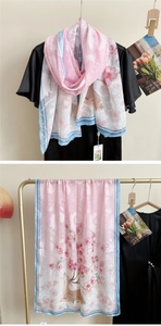 Détail d'une écharpe dégradée rose avec motifs fleurs et cerfs sur tissu soyeux