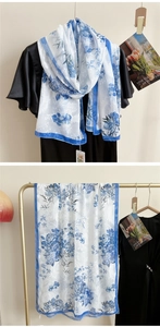 Vue détaillée d'une écharpe blanche avec motifs floraux bleus et texture de soie fine