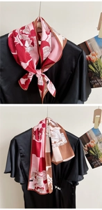 Detail of red and pink floral twilly scarf styled as a bow tie and hanging tie