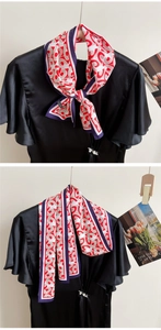 Detail of red and white geometric silk scarf tied on a black dress with sleek texture