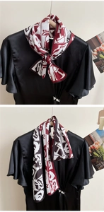Detail of red and black geometric silk scarf styled as an elegant necktie and a drape