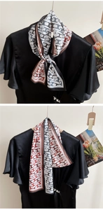 Detail of silk-like neckerchief with geometric patterns styled on black satin top