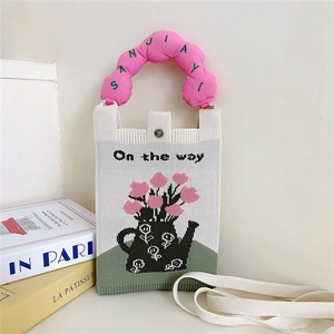 Détail du sac tricoté mignon avec broderie florale et poignée rose en forme de nuage