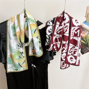 Dual-sided silk scarves with lemon print and retro geometric patterns on hangers