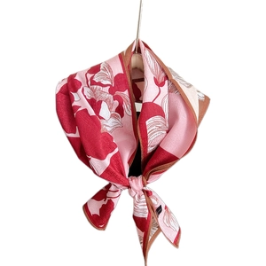 Pink and red floral silk scarf tied elegantly on a hook with brown stitched edges