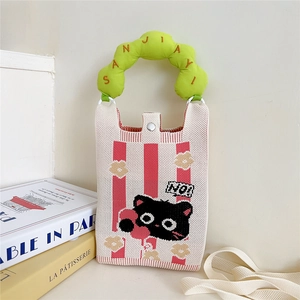 Détail du sac tricoté à rayures rouges et blanches avec poignée verte et motif chat
