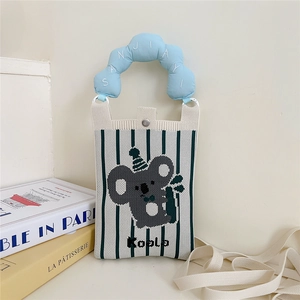 Gros plan du sac en tricot avec motif koala, poignée ondulée bleue et bouton pression