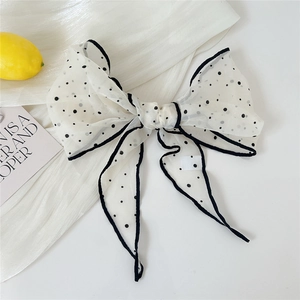 Close-up of lightweight white organza bow hair clip with black polka dots and silk piping