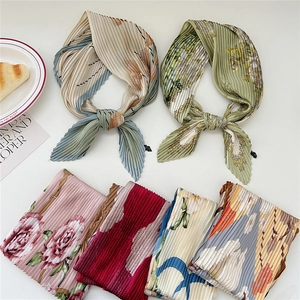 Elegant pleated silk scarves with floral and geometric patterns on white background