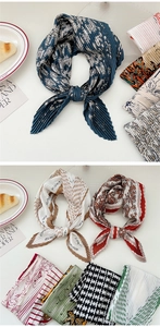 Detailed view of pleated square scarves with elegant floral patterns and accordion folds