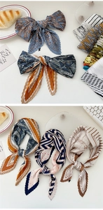 Detail of assorted pleated silk scarves featuring paisley patterns and geometric prints