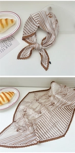 Detail of pleated floral square scarf in brown and white with chic croissant lifestyle styling