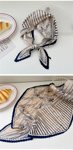 Detail of pleated silk scarf with navy line art and elegant crinkle texture for hair