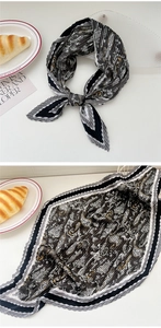 Detailed view of pleated silk scarf with Paisley pattern and black and white striped border