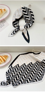 Detail of pleated silk scarf with black zigzag patterns and yellow polka dots