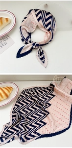 Detailed view of pink pleated silk scarf featuring navy zigzag lines and red polka dots