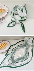 Macro detail of green and white pleated square scarf with floral print pattern