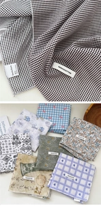 Detail of assorted 100% cotton square scarves featuring various prints and fabric texture