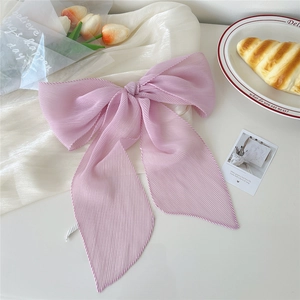 Dettaglio del fiocco per capelli viola plissettato in chiffon con trama fine e clip