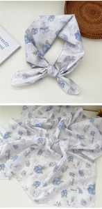 Close-up of floral cotton scarf showing refined blue patterns and 100% cotton label