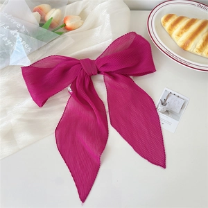 Dettaglio sciarpa di seta plissettata fucsia con ciondolo a stella in set da tè