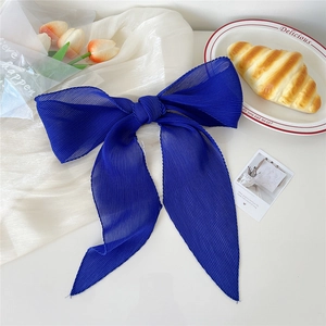 Dettaglio di fiocco per capelli in chiffon a pieghe blu reale con nastri lunghi ed eleganti