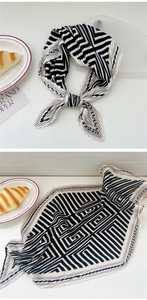 Detail of pleated silk scarf with black and white geometric patterns and dot borders
