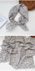 Close-up of 100% cotton floral scarf with blue and brown patterns in a flat lay view