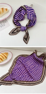 Detail of pleated square scarf with purple and pink geometric patterns in a lifestyle setting