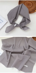 Detail showing 100% cotton black and white gingham scarf with texture and care label