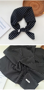 Detailed texture of a classic black polka dot cotton scarf showing soft fabric weave