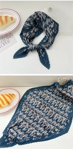 Detailed view of dark blue pleated scarf with white paisley pattern and elegant texture