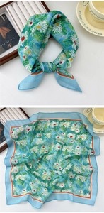 Detail of light blue square silk scarf featuring white daisy floral prints and orange borders