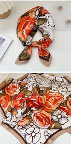 Detail of floral silk scarf featuring orange roses and olive green leaves on white silk