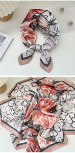 Detailed close-up of a floral satin square scarf with elegant rose patterns and border