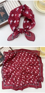 Close-up of burgundy floral silk scarf with contrast border and soft elegant texture