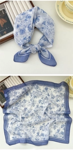 Detailed close-up of a floral cotton linen scarf with blue floral prints and blue borders