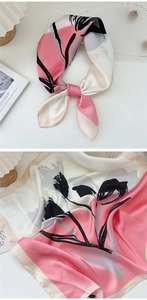 Detailed close-up of smooth satin square scarf with elegant abstract floral print