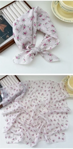Detail of white cotton linen scarf with small pink and purple floral prints for women