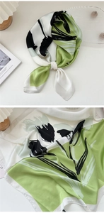 Detail of silk scarf with green floral pattern and pearlescent satin texture for women
