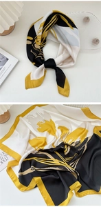 Close-up of an abstract floral silk scarf in yellow, black and beige with soft texture
