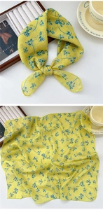 Detail of yellow cotton silk scarf with blue floral prints and tied bow styling