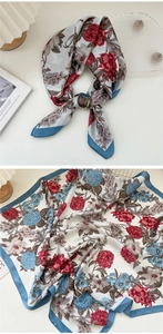 Detail of floral silk scarf featuring digital print of red and blue flowers with navy border