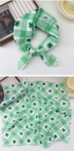 Close-up of green clover print cotton linen scarf with plaid pattern and laundry tag