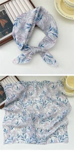 Close-up of lightweight cotton linen scarf with blue leaf patterns and fine stitched edges