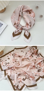 Detailed close-up of a floral silk scarf with apricot pink tones and brown borders